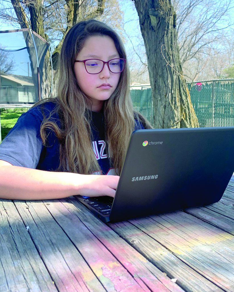 Girl is outside using a laptop