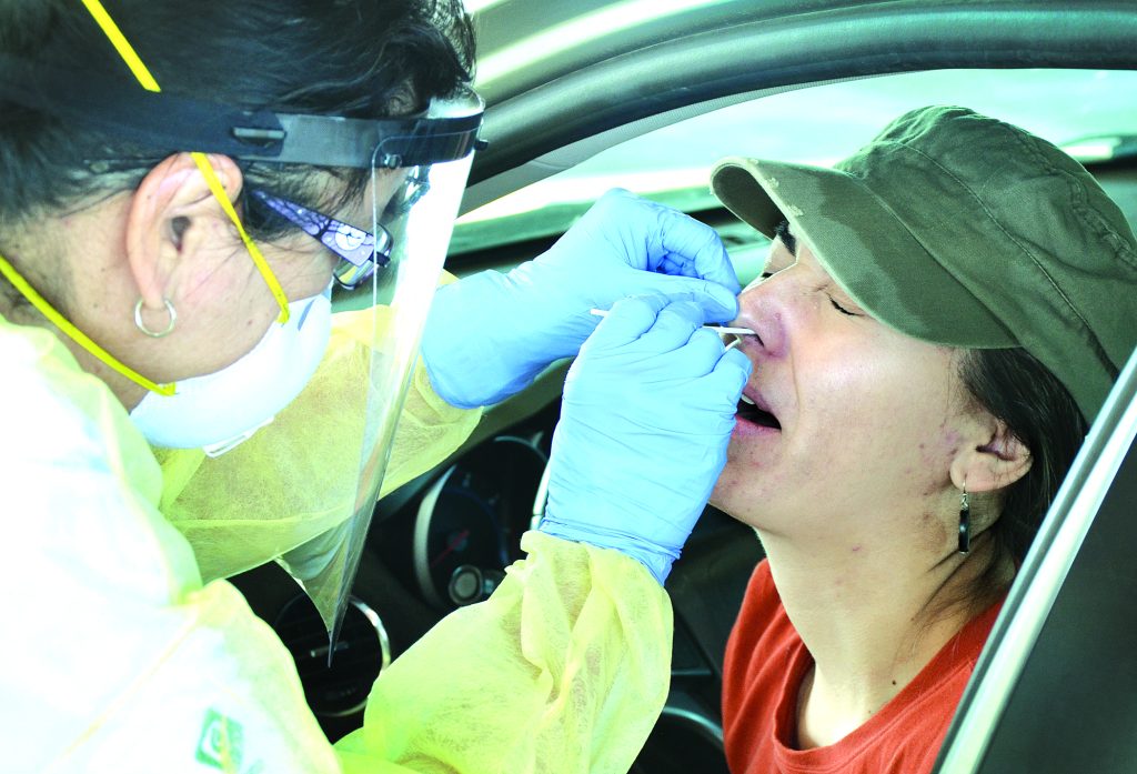 Patient getting her nose swabbed by a nurse.